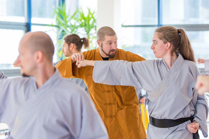 Gruppenunterricht im Shaolin Chan Tempel Luzern - Schweiz. Meister Shi Yong Wen, Thomas Degen, korrigiert eine Schülerin.